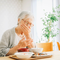 食事中にむせる女性