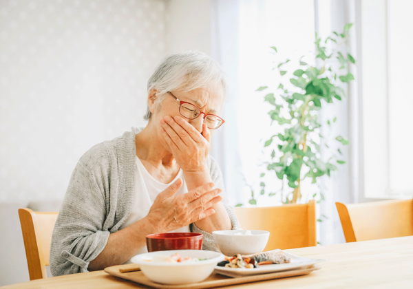 食事中にむせる女性